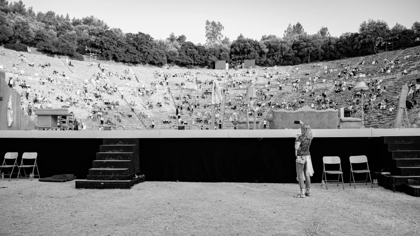 a person standing at a stage in front of some empty chairs