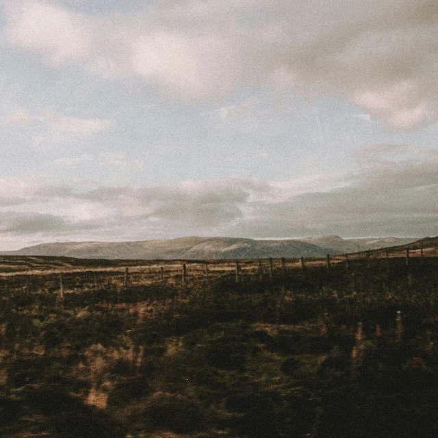 the mountains are dotted with clouds in the background