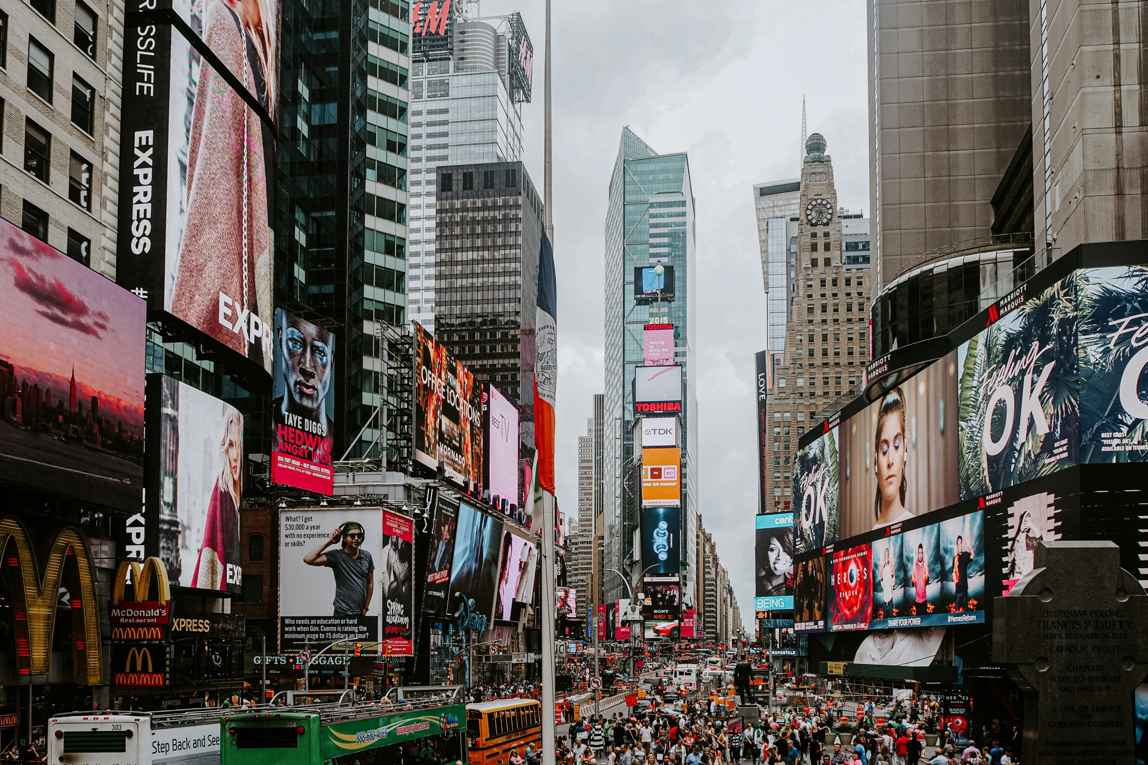 a crowded street is filled with people and billboards