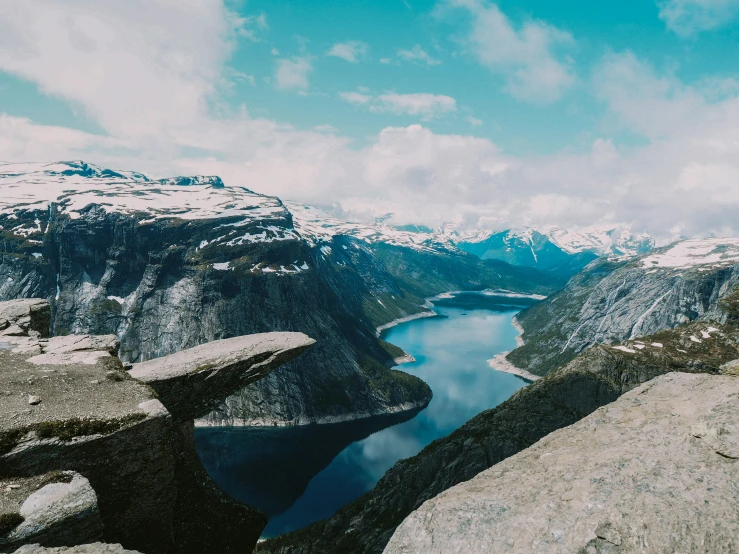 an area with very high mountains, some rocks and water