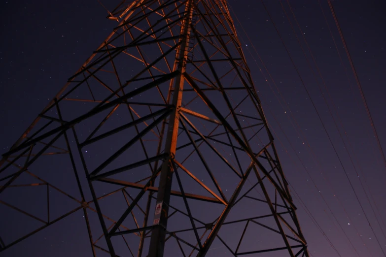 a tall metal tower with a dark night sky behind it