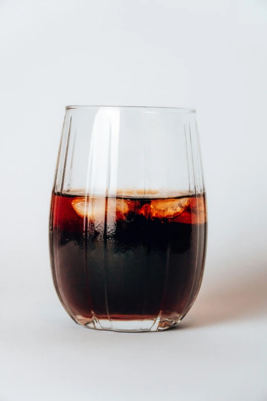 a glass of wine is shown with red liquid