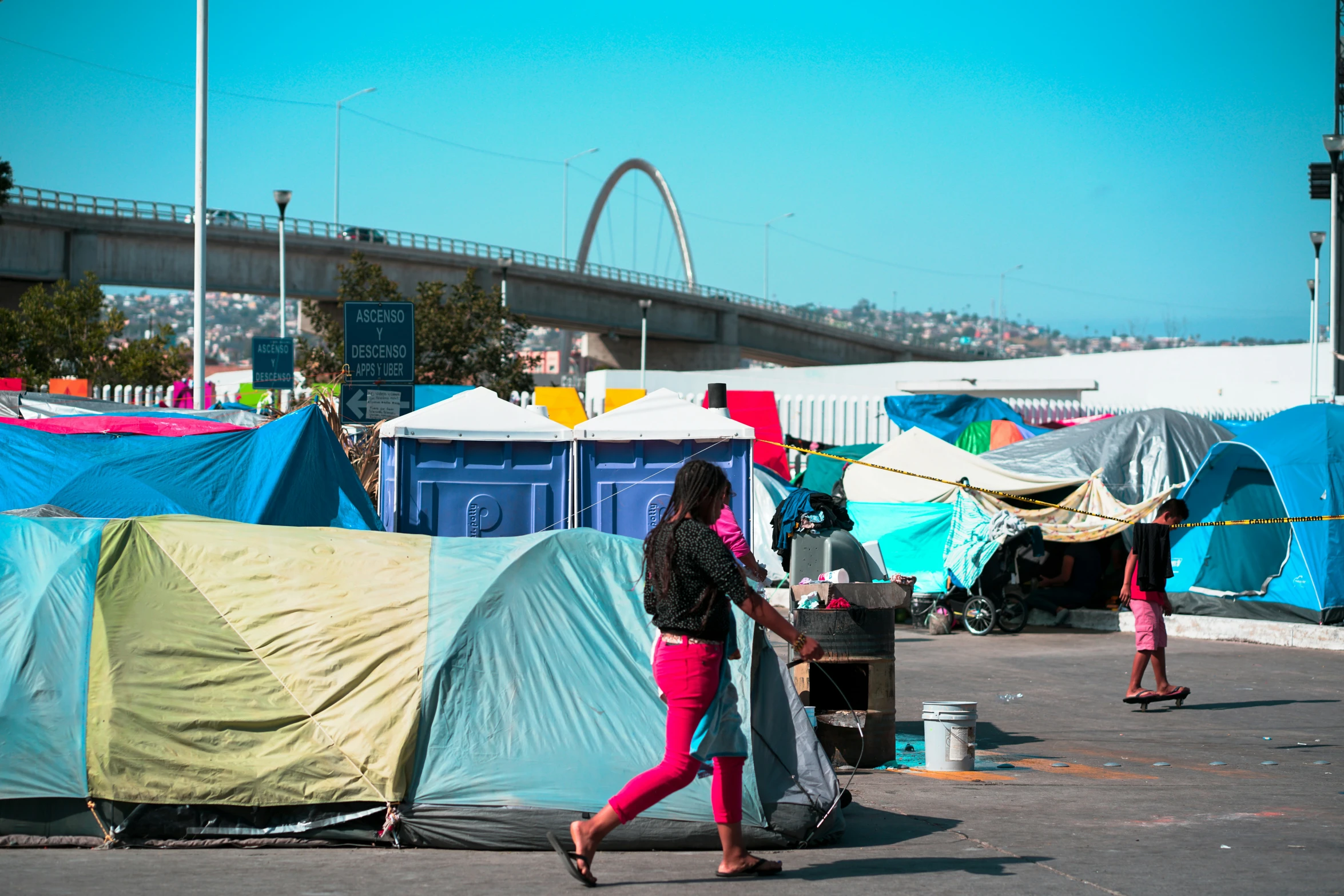 a woman walking down a street next to tents