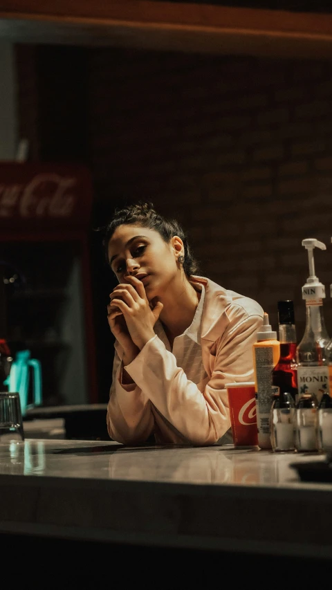 a woman is at a counter in front of some bottles