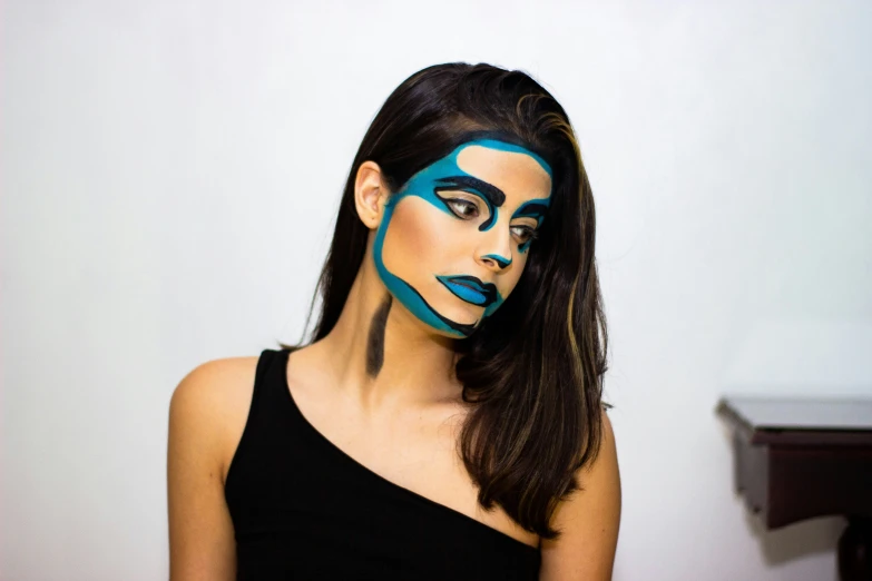 a woman in a black top with blue face paint