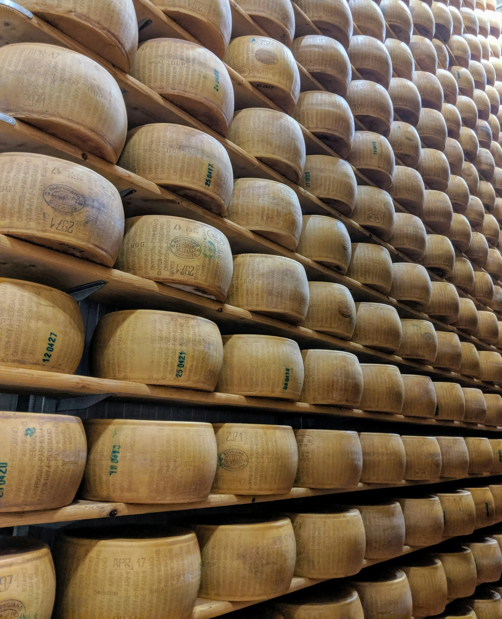 many stacks and piles of cheese on shelves