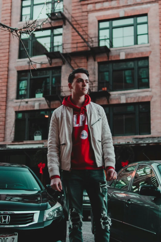 a man standing on the sidewalk next to parked cars