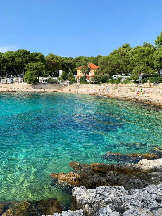 a rock shore with green and blue water