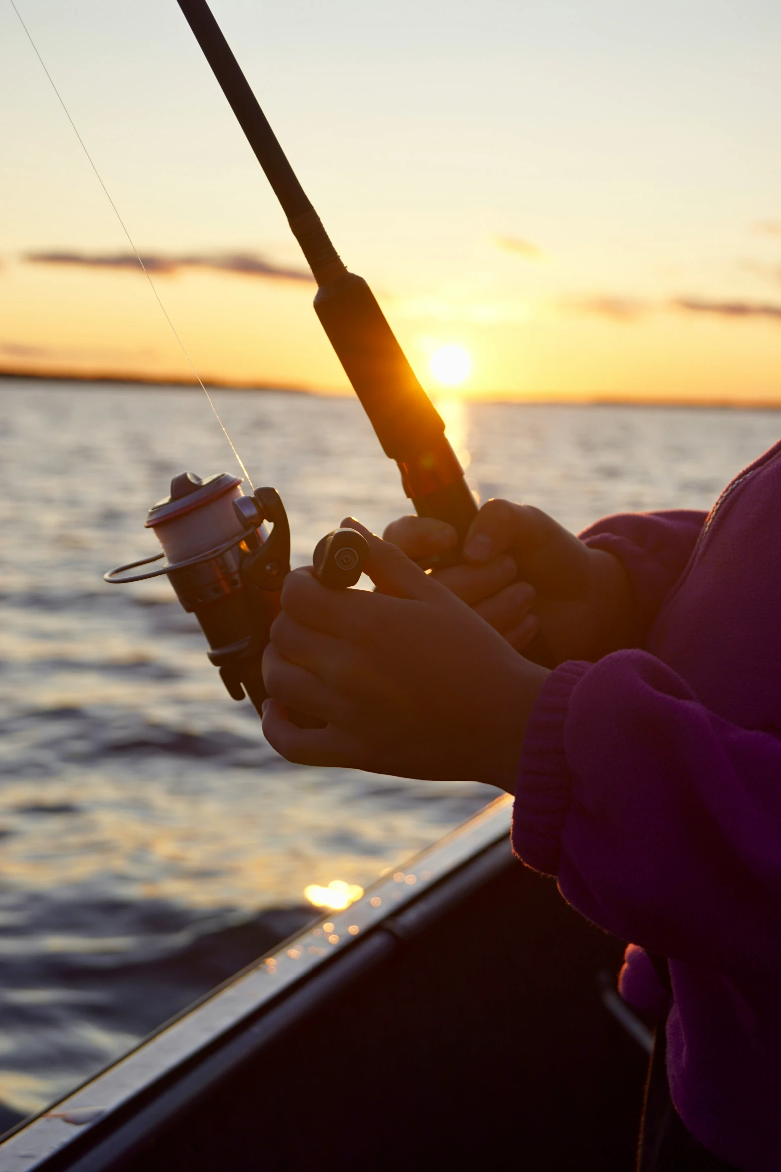 a person holding a fishing rod next to the ocean