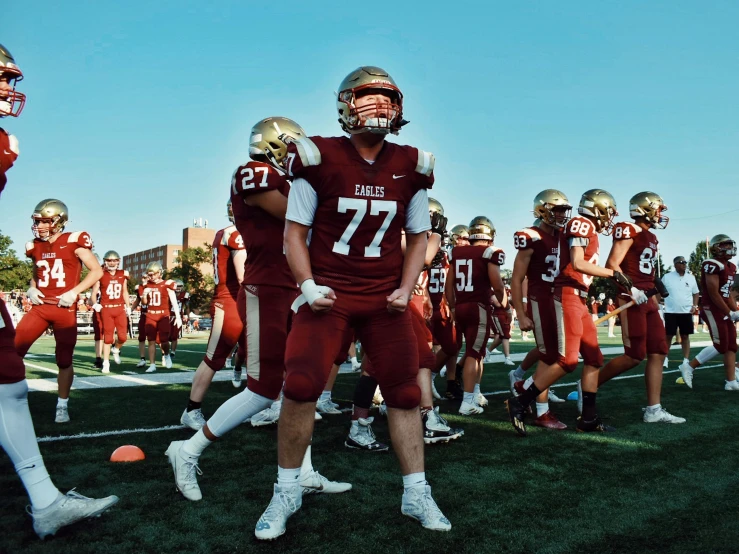 some men are wearing football uniforms on the field