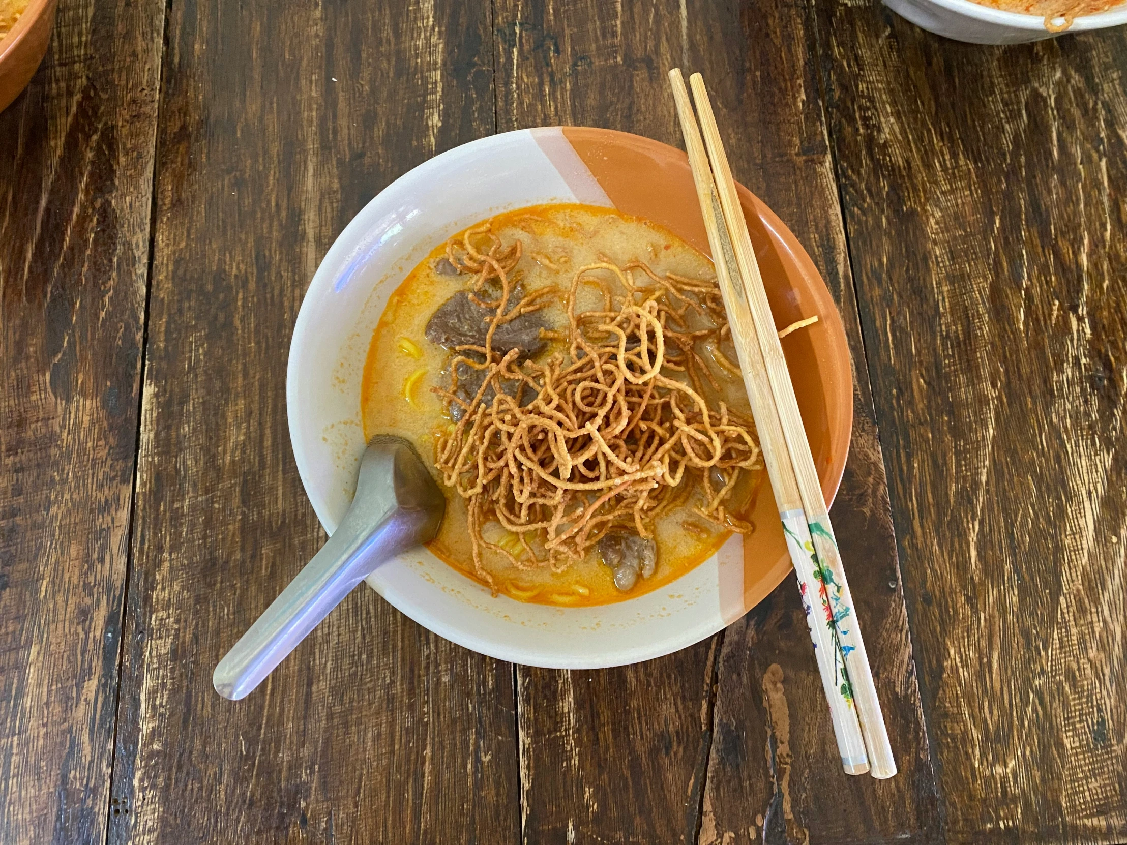 a bowl of ramen and two chop sticks sitting on a table