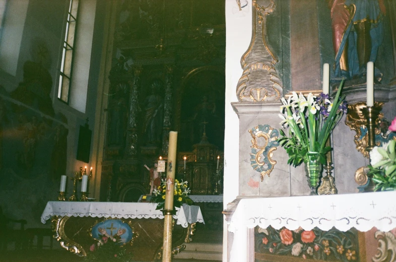 an altar with candles, flowers and a cloth