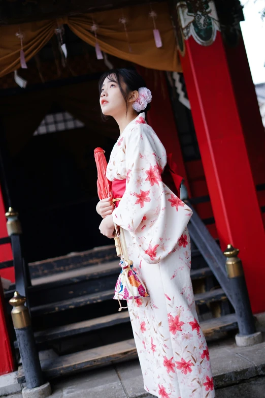 a beautiful woman standing in front of a red building