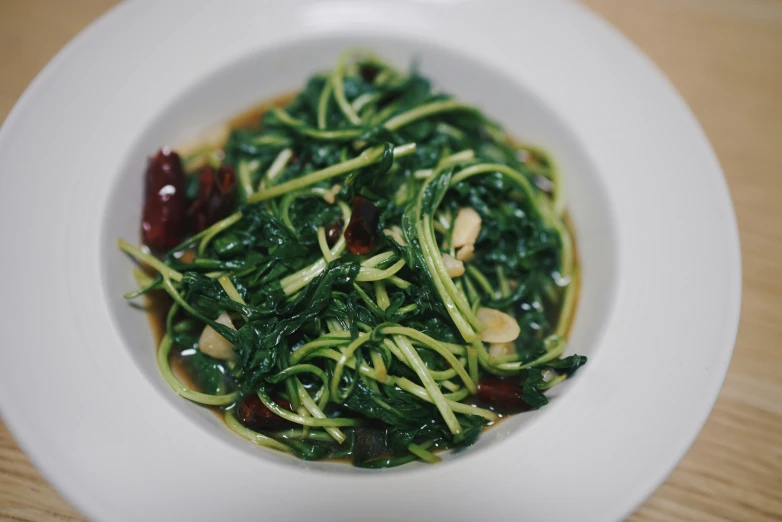 green stir fried food with spinach in a bowl