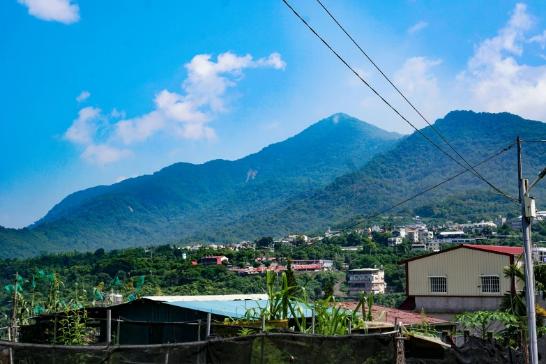 a fence on the side of a road in front of mountains