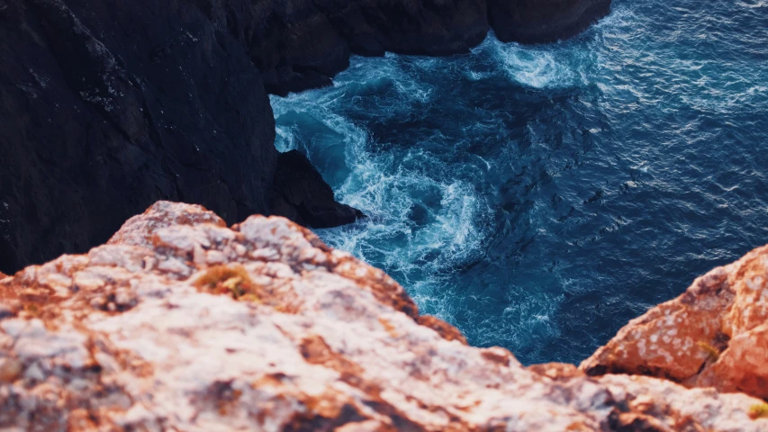 a closeup of a rock wall next to the ocean