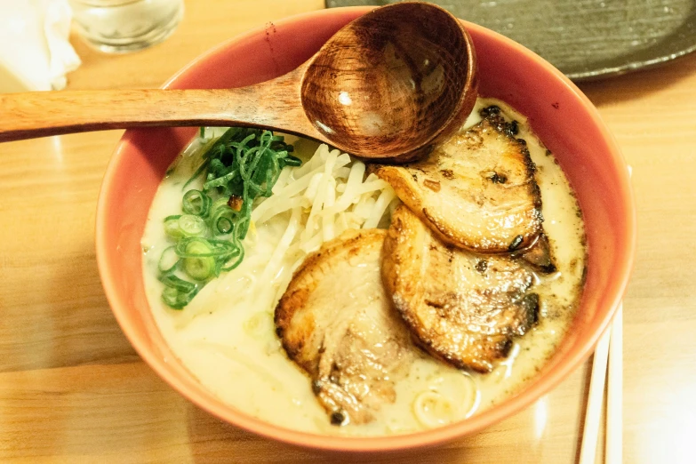 a bowl with some chicken, noodles and greens