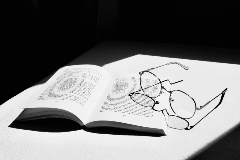 glasses are shown sitting on top of an open book
