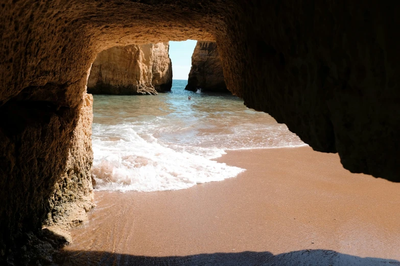 the view from inside a cave on the beach