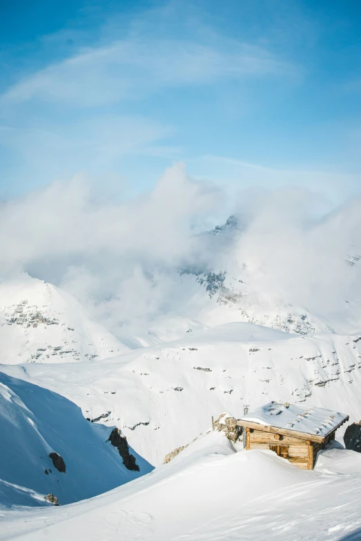 a person standing on a snowy hill in front of a mountain