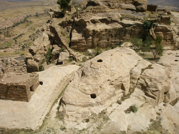 a big rocky cliff with small holes in the rocks