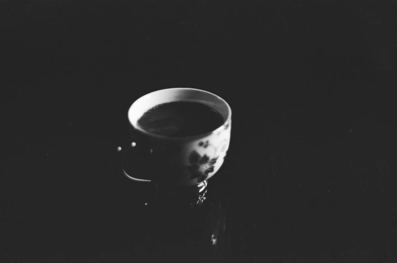 black and white po of a coffee cup with black dots on it