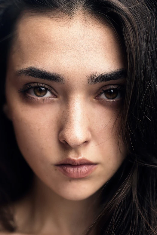 a woman's face with dark long hair and large eyes