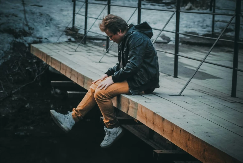 man sitting on a dock in the water