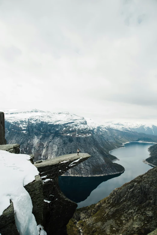 a mountain peak with a long narrow cliff with a man on top