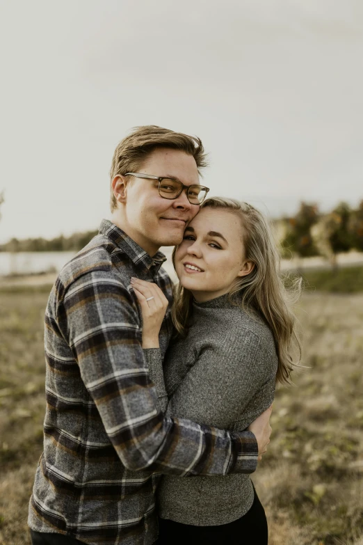 the couple pose for a po together in a field