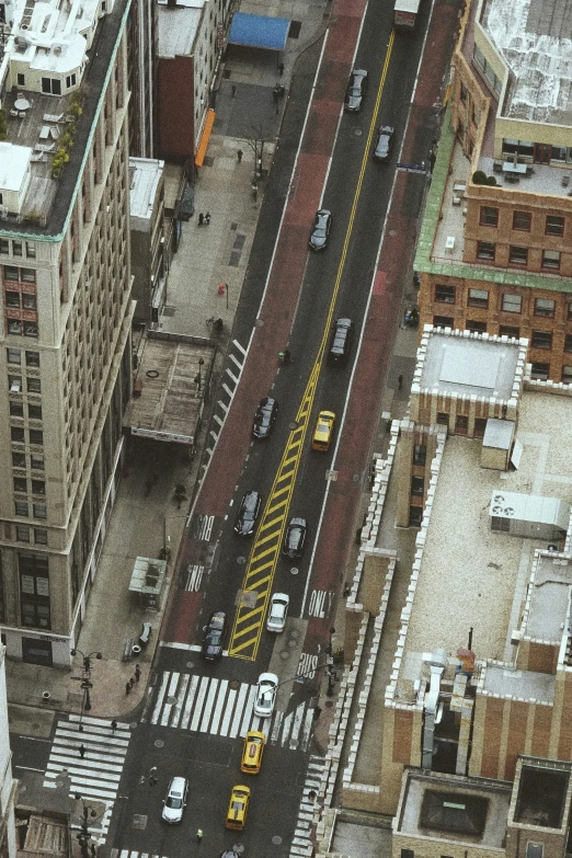 this aerial po depicts a city street with taxis and pedestrian traffic