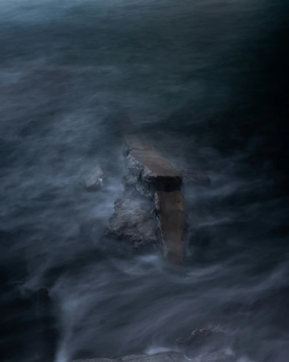 water passing by a wooden fence and rocks