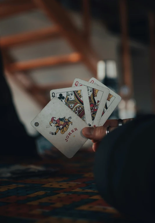 the man holds five playing cards in his hand