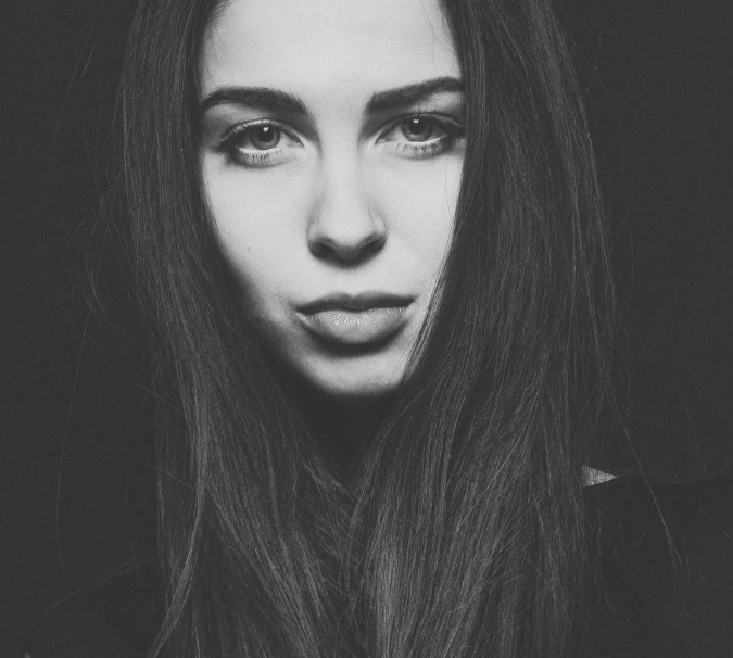 a black and white image of a woman with long dark hair