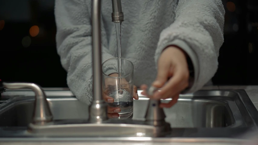 a person who is filling up a beverage in a glass