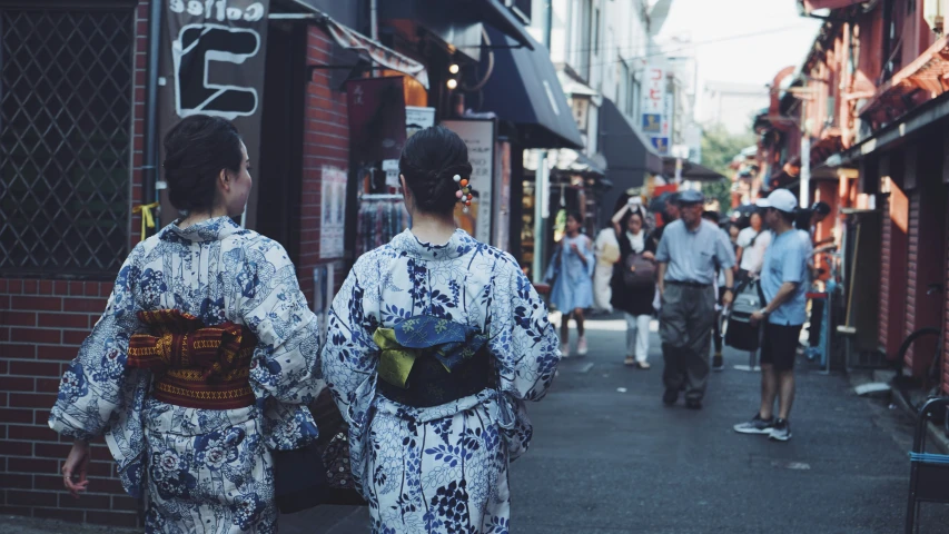 the people are walking down the street wearing oriental garb