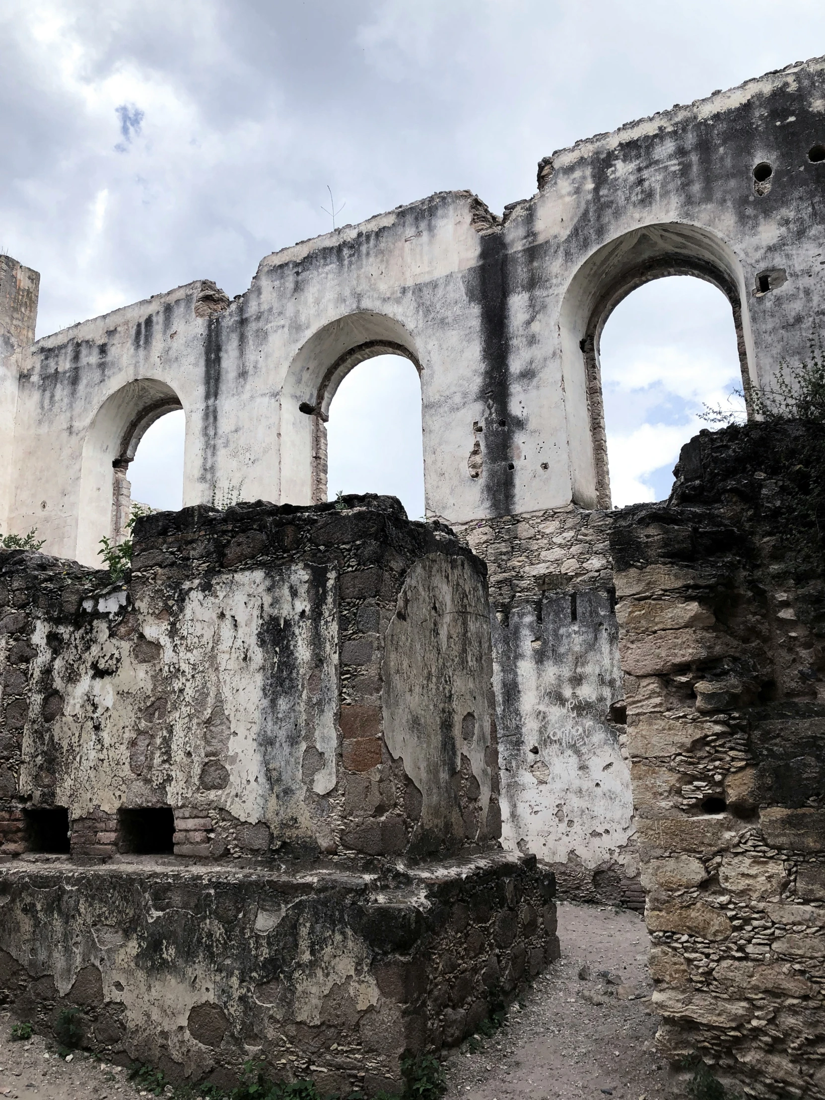 a run down building with arched windows and stairs