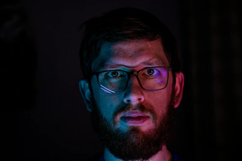 a bearded man wearing glasses and a tie