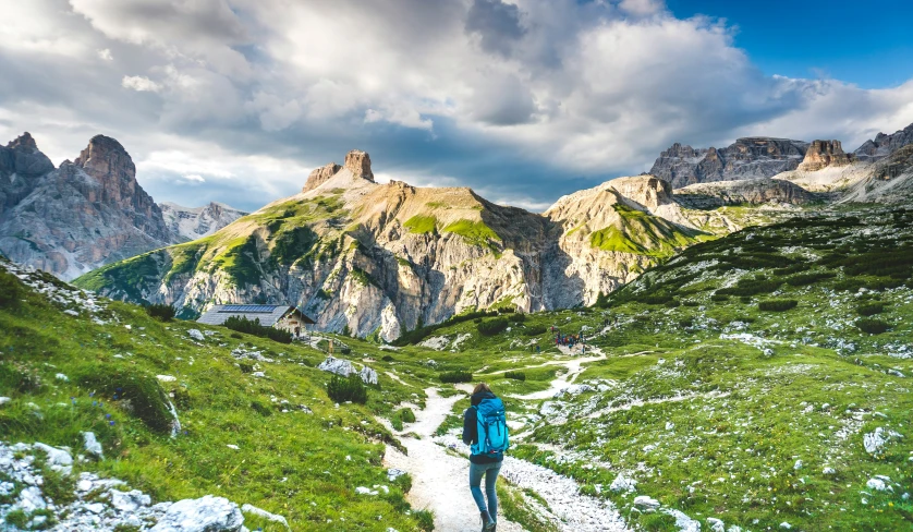 a man walking on the side of a mountain trail