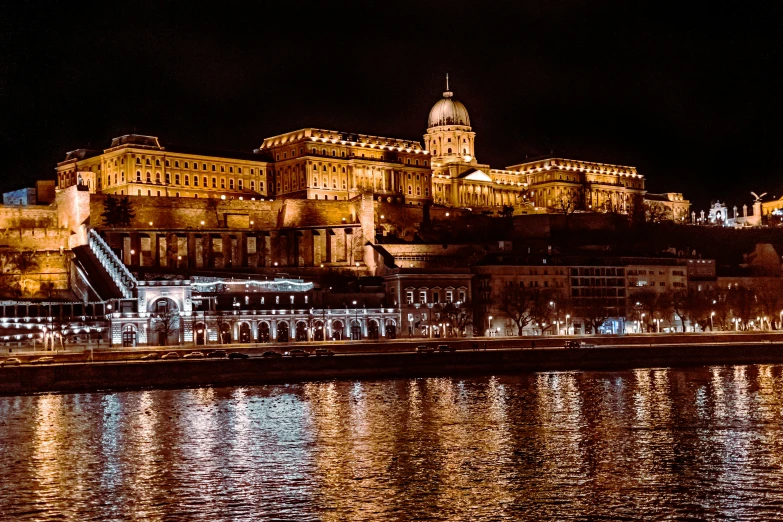 an illuminated castle with a lake in front of it