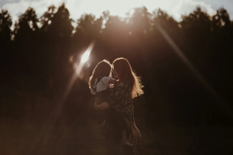 a couple hugging in front of some trees