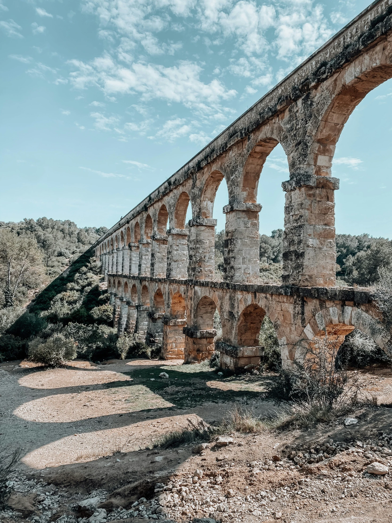 a bridge built around a stone block near a river