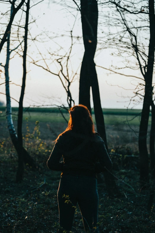 the woman is walking in the woods alone