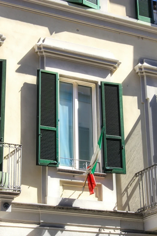 an italian window has been decorated with green shutters