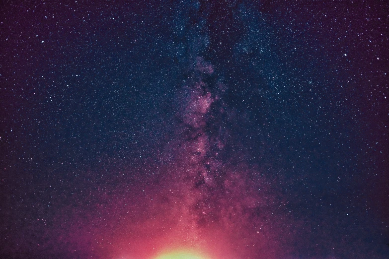 a view of a colorful light at the bottom of a sky with stars