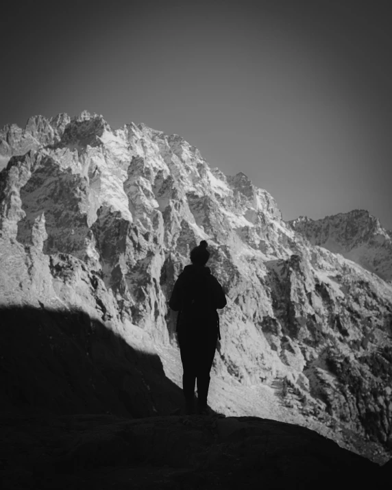 a man standing in front of a snow covered mountain