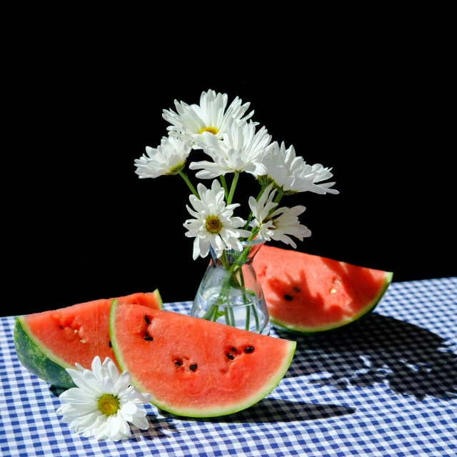 the flowers are near the sliced watermelon