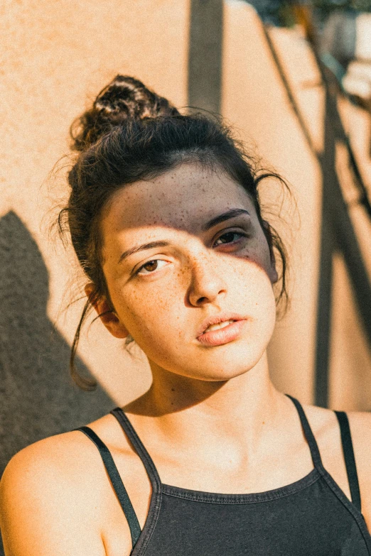 a woman wearing a tank top has her arms folded out, and looking directly into the camera