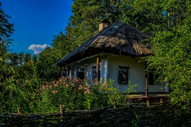 a white house with a small roof is surrounded by trees