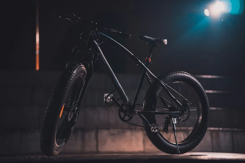there is a dark bicycle parked in the dark